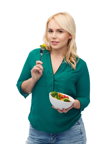 Sorrindo jovem mulher comendo salada de legumes — Fotografia de Stock