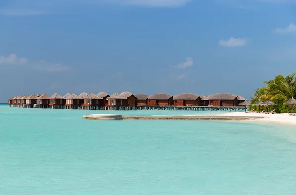 Bungalow hutten in zeewater op exotische resort strand — Stockfoto