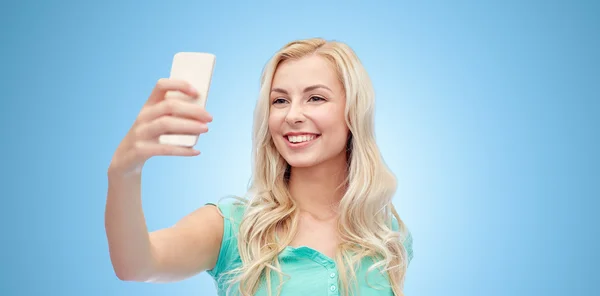 Усміхнена молода жінка бере селфі зі смартфоном — стокове фото
