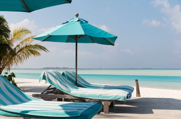 Parasol and sunbeds by sea on maldives beach — Stock Photo, Image