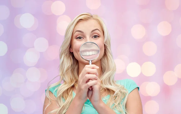 Happy young woman with magnifying glass — Stock Photo, Image