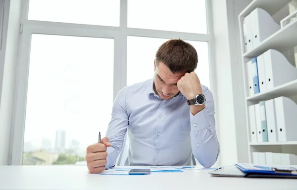 Homem de negócios estressado com papéis no escritório — Fotografia de Stock