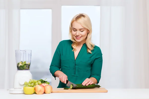 Lachende vrouw met blender koken voedsel thuis — Stockfoto