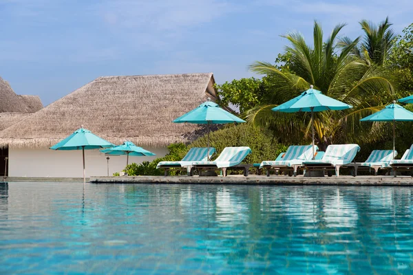 Parasol et chaises longues par la mer sur la plage des Maldives — Photo