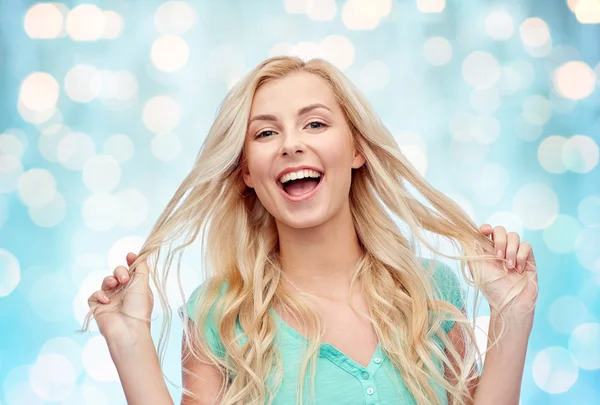 Sorrindo jovem segurando seu fio de cabelo — Fotografia de Stock