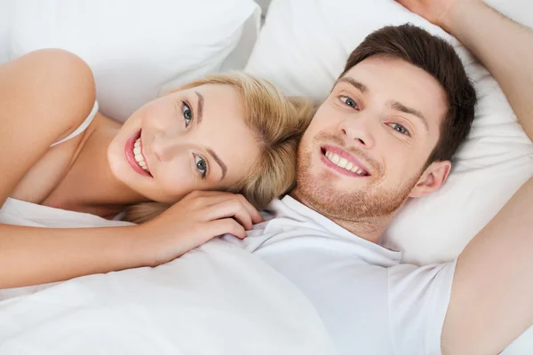 Felice coppia sdraiata a letto a casa — Foto Stock