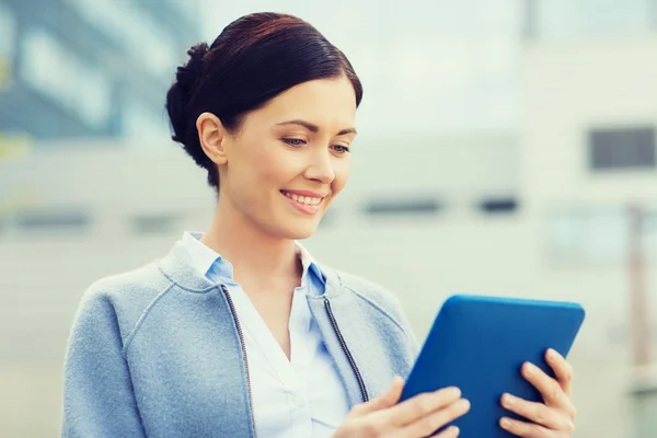 Sonriente mujer de negocios con tablet pc en la ciudad —  Fotos de Stock