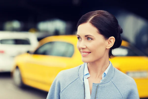 Улыбающаяся женщина над станцией такси или городской улицей — стоковое фото