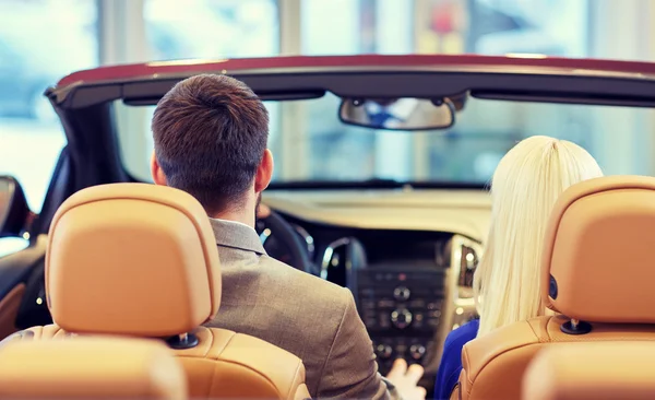 Couple sitting in cabriolet car at auto show — Stock Photo, Image