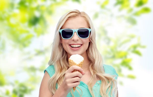 Счастливая молодая женщина в солнечных очках ест мороженое — стоковое фото