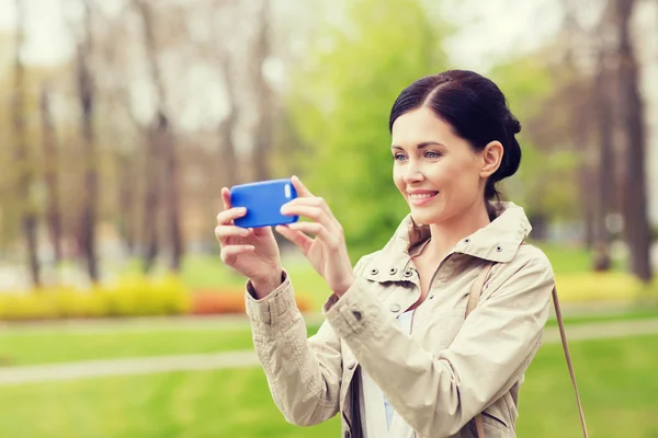 Donna sorridente scattare foto con smartphone — Foto Stock