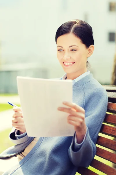 Sorridente empresária ler papéis ao ar livre — Fotografia de Stock