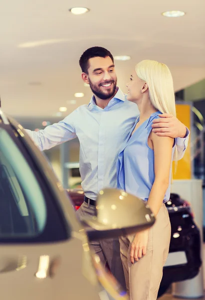 Feliz pareja comprando coche en auto show o salón —  Fotos de Stock