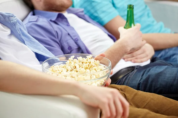 Close up of friends with beer and popcorn at home — Stock Photo, Image