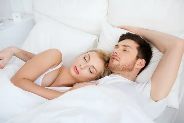 Szczęśliwa para śpiąca w łóżku w domu — Zdjęcie stockowe