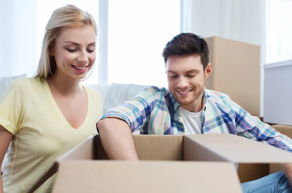 Sonriente pareja con grandes cajas moviéndose a nuevo hogar — Foto de Stock