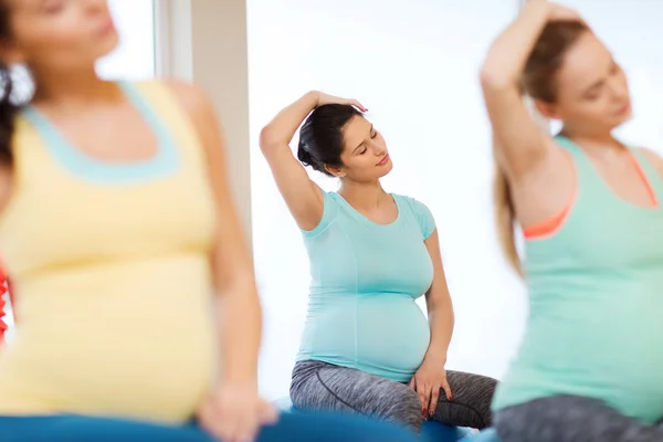 Glada gravida kvinnor utövar på fitball i gym — Stockfoto