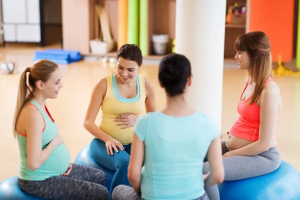 Mutlu hamile kadınlar spor salonunda topların üzerinde otururlar. — Stok fotoğraf