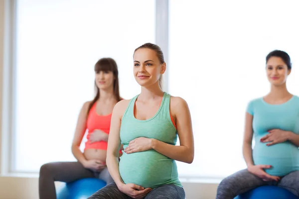 Счастливые беременные женщины, занимающиеся фитболом в тренажерном зале Лицензионные Стоковые Изображения