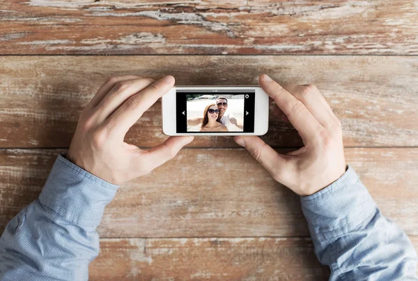 Närbild av manliga händer med foto på smartphone — Stockfoto