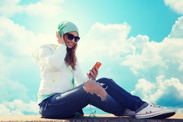 Glad ung kvinna med smartphone och hörlurar — Stockfoto