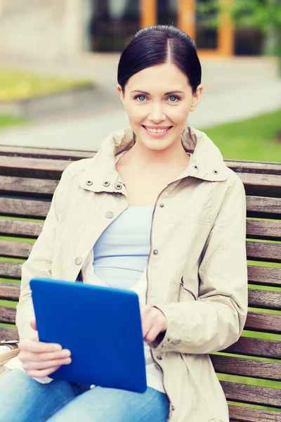 Kvinna med TabletPC sitter på bänken i park — Stockfoto