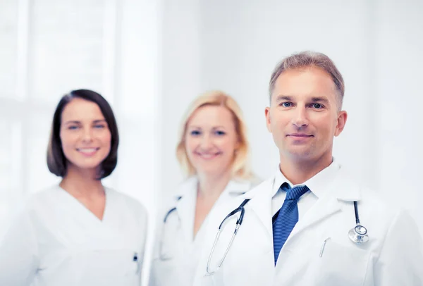 Doctor with stethoscope and colleagues — Stock Photo, Image