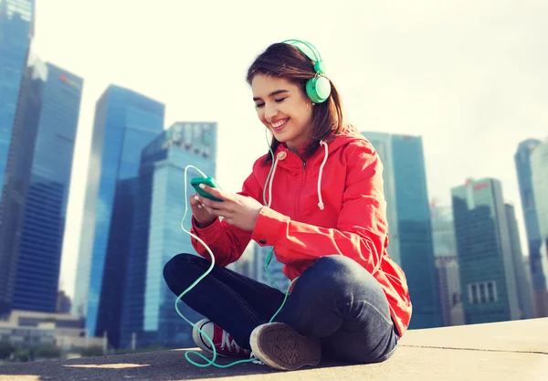 Happy young woman with smartphone and headphones — Stock Photo, Image