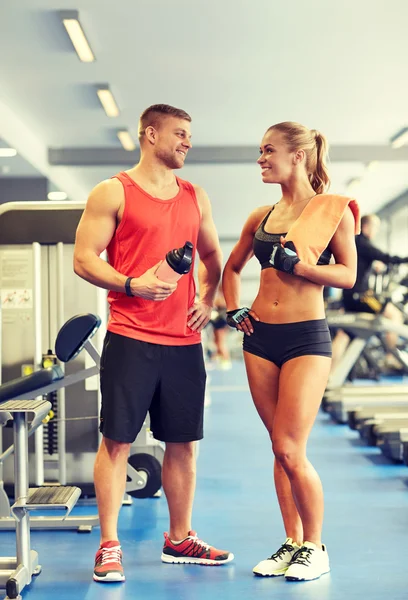 Uomo e donna sorridenti che parlano in palestra — Foto Stock