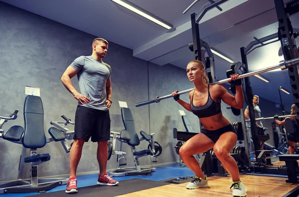 Man en vrouw met barl buigen spieren in sportschool — Stockfoto