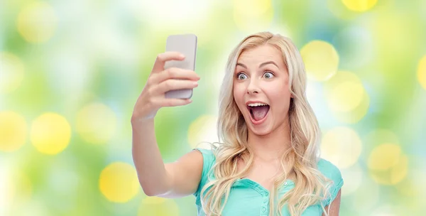 Smiling young woman taking selfie with smartphone — Stock Photo, Image