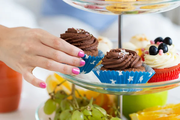 Primer plano de la mano tomando cupcake de pie de la torta — Foto de Stock