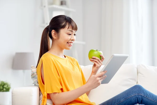 Felice donna asiatica con tablet pc e mela a casa — Foto Stock