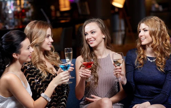 Mulheres felizes com bebidas no clube noturno — Fotografia de Stock