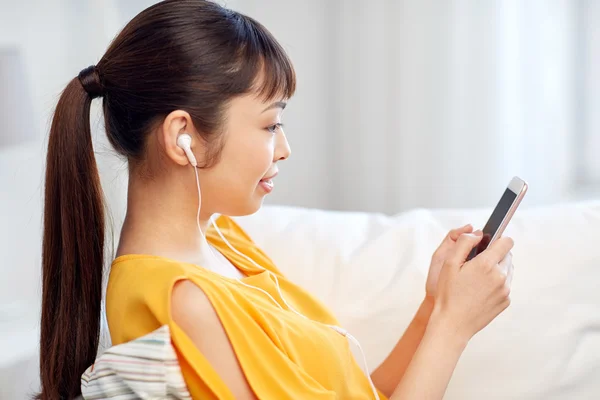 Mujer asiática feliz con teléfono inteligente y auriculares —  Fotos de Stock