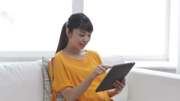 Счастливая молодая женщина с планшетным компьютером дома — стоковое видео