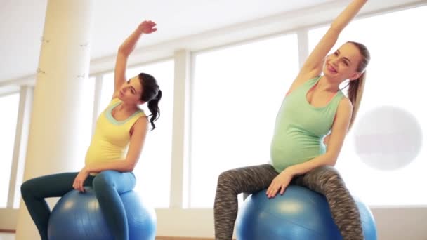 Femmes enceintes heureux faisant de l'exercice sur fitball dans la salle de gym — Video