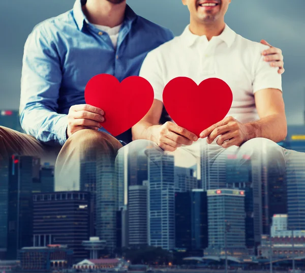 Close up of happy gay male couple with red hearts — Stock Photo, Image