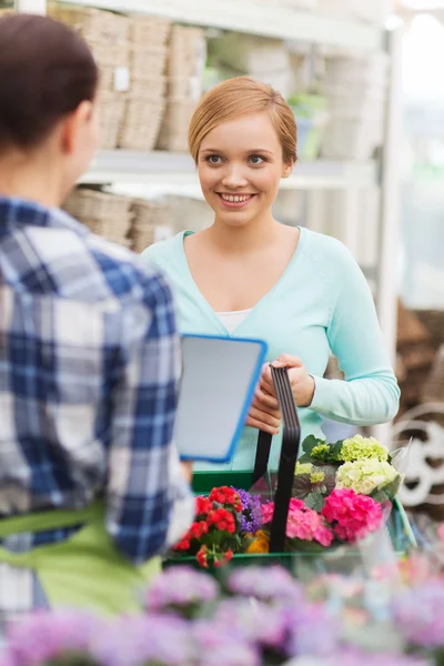 Happy women with tablet pc at flower shop — Stock Photo, Image