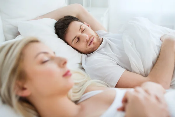 Casal feliz dormindo na cama em casa — Fotografia de Stock