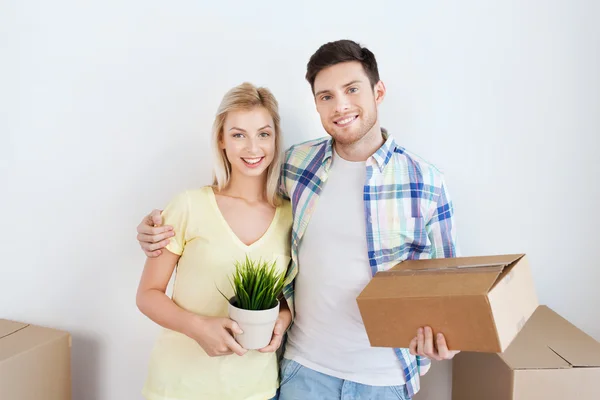 Sonriente pareja con grandes cajas moviéndose a nuevo hogar — Foto de Stock