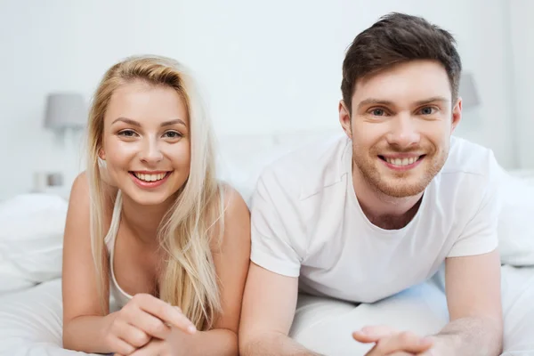 Feliz pareja acostada en la cama en casa —  Fotos de Stock