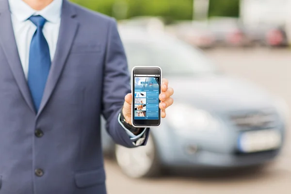 Close up of business man with smartphone and car — Stock Photo, Image