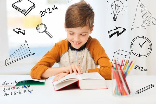 Sorridente, studente ragazzo lettura libro a casa — Foto Stock