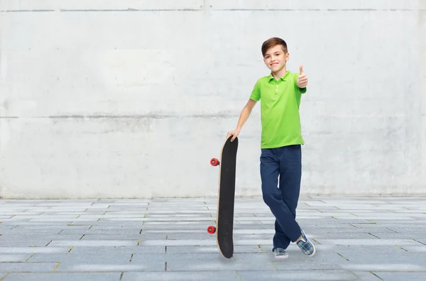 Šťastný chlapec s skateboard ukazovat palec — Stock fotografie