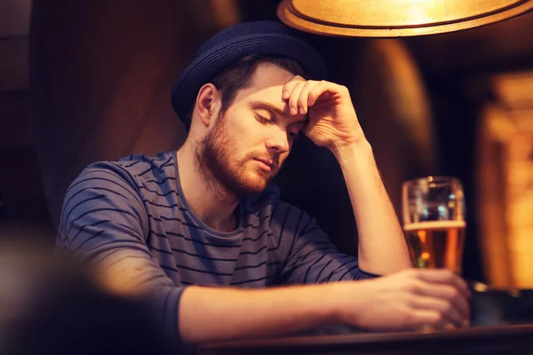 Unhappy lonely man drinking beer at bar or pub — Stock Photo, Image
