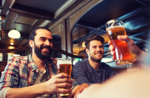 Happy male friends drinking beer at bar or pub — Stock Photo, Image