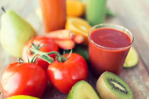 Close up of fresh juice glass and fruits on table — Stock Photo, Image