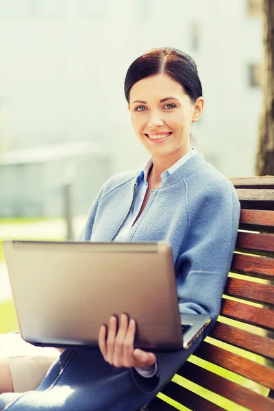 Şehir içinde laptop ile gülümseyen iş kadını — Stok fotoğraf
