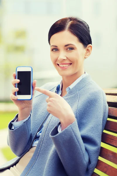 Junge lächelnde Geschäftsfrau zeigt Smartphone — Stockfoto